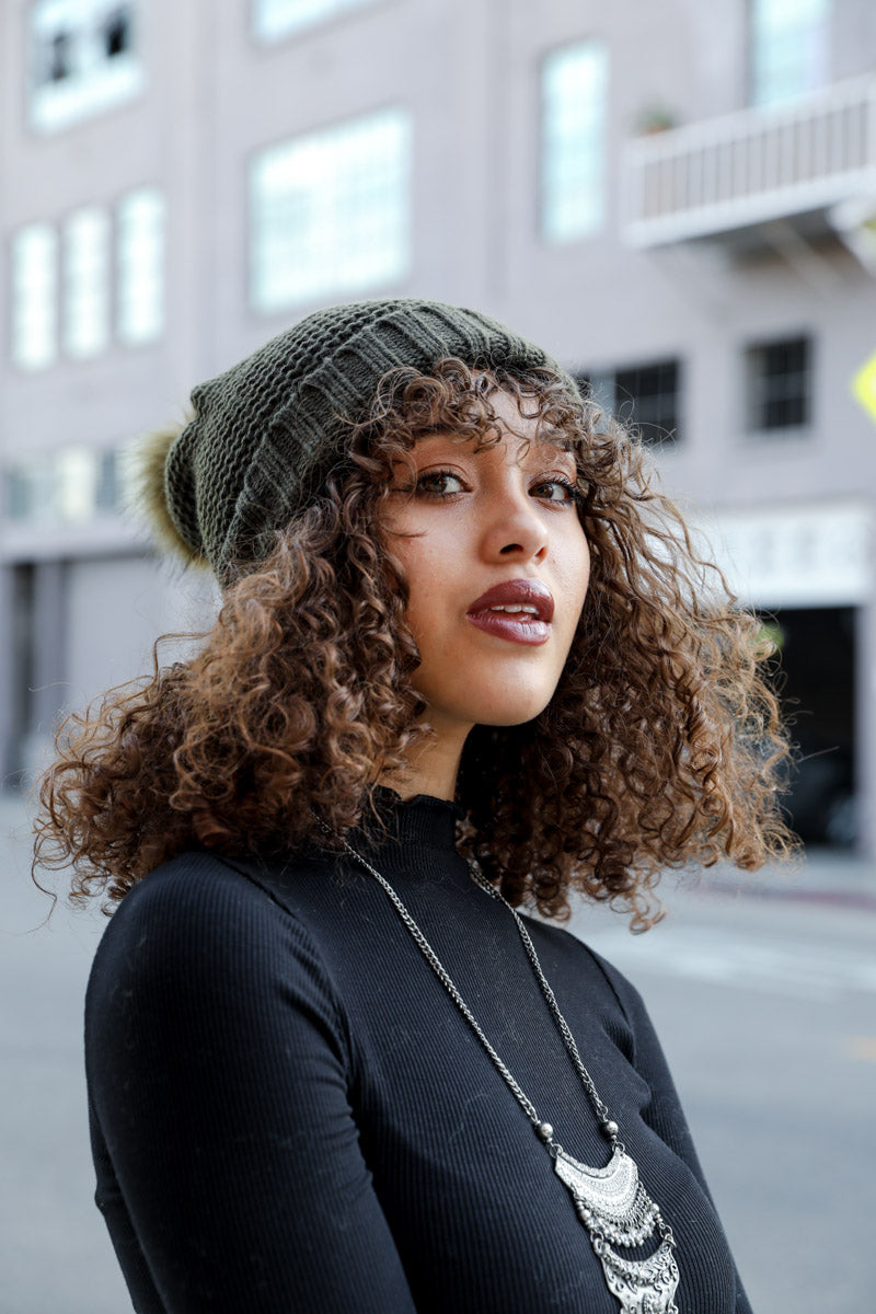 Olive green Pom Beanie by Leto Collection with plush faux Sherpa lining, cozy and stylish for cold weather.