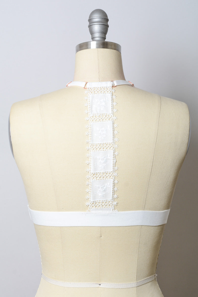 White crochet T-back bralette from Leto Collection with intricate lace detailing and comfortable fit.