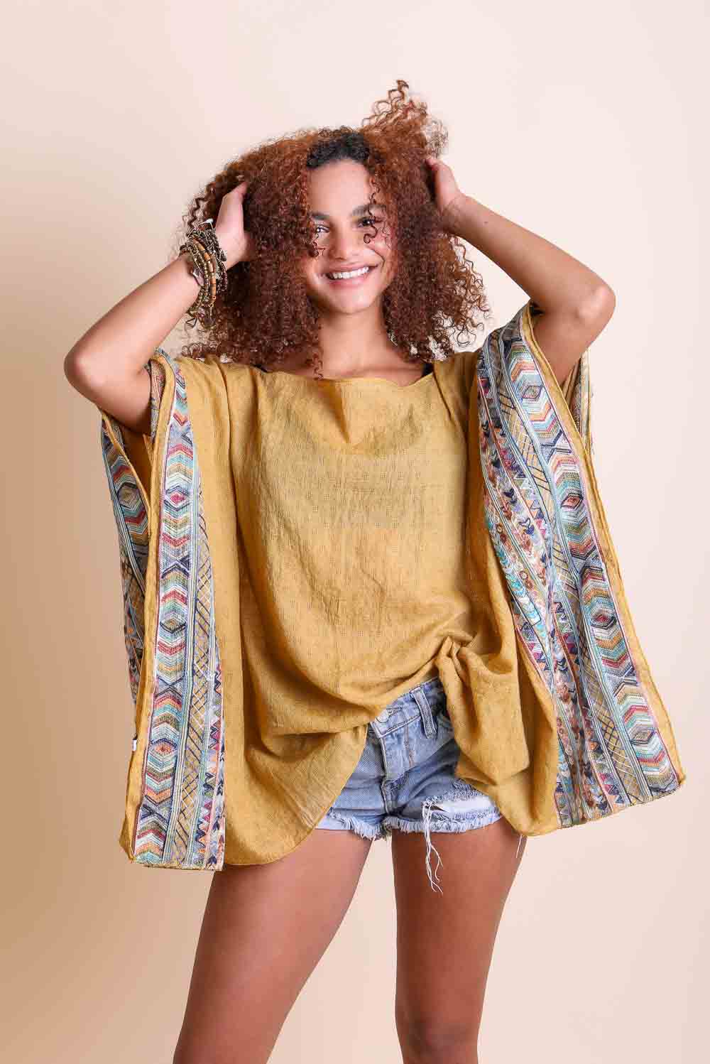 Leto Collection geometric embroidered kimono tunic with colorful patterns and flowing fabric, displayed on a hanger.